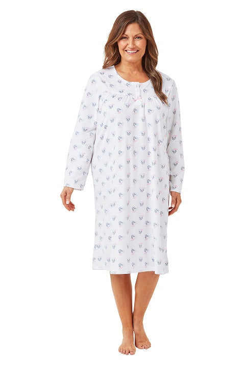 Woman wearing a white nightgown with a pattern on a white background